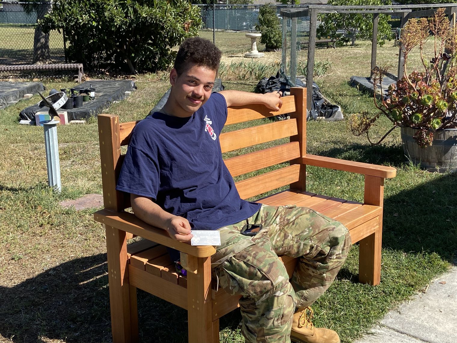 Man sits on a bench in a garden