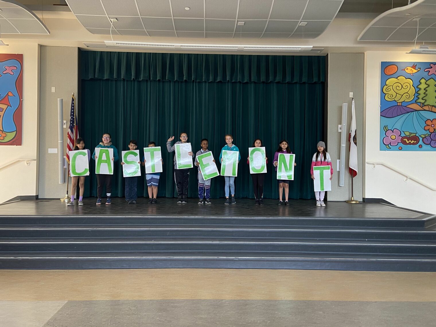Group of students holding letter signs on a stage
