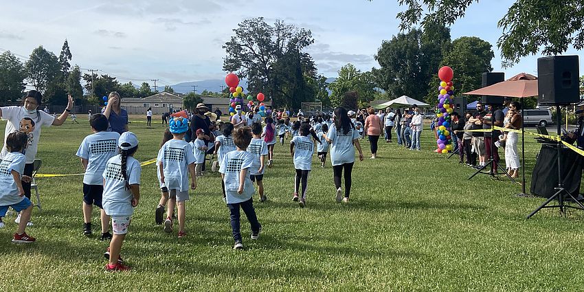 Children walking and running on a grassy field