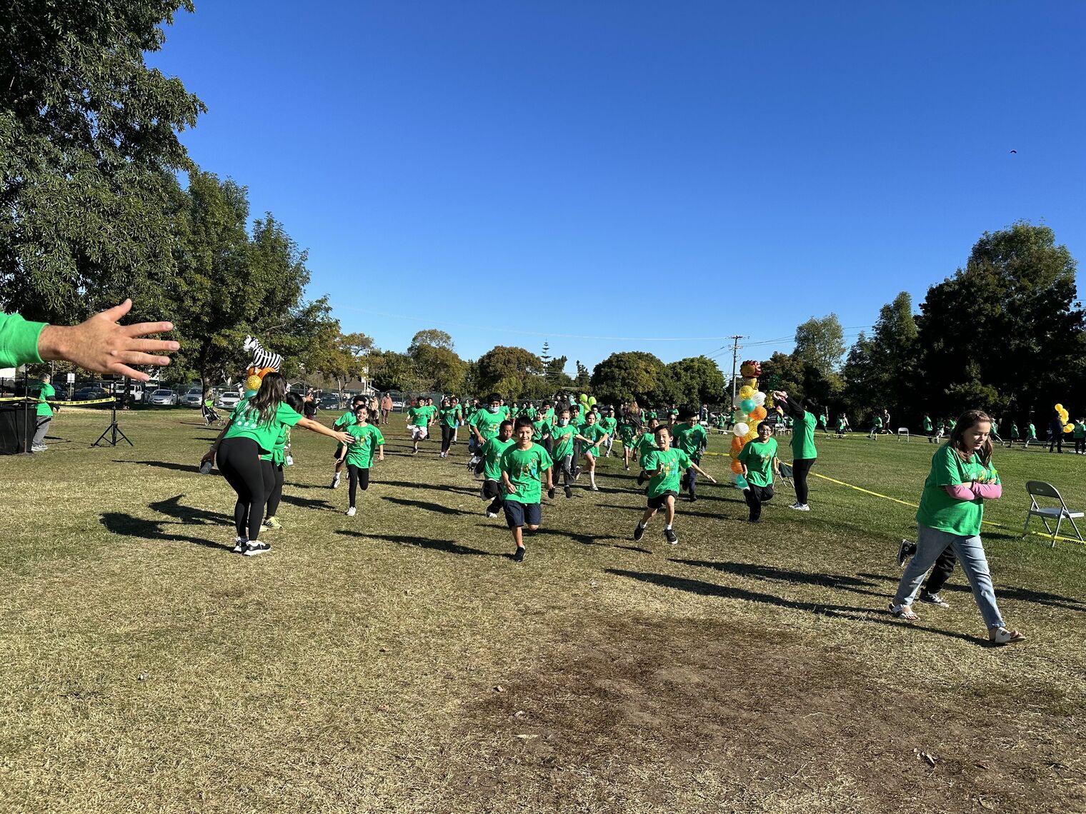 Children running and walking on a grass field