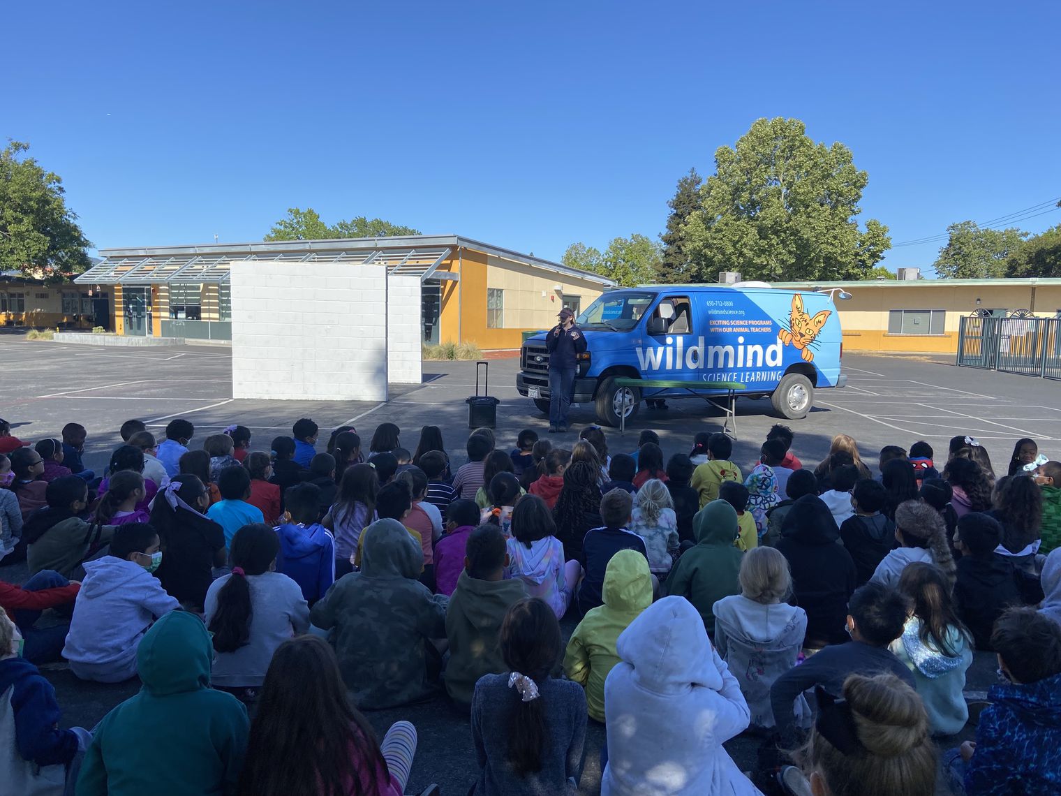 A van in front of student seated outdoors