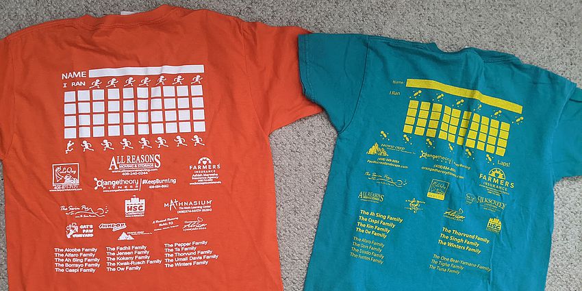 Two short-sleeve tshirts with writing on the back.