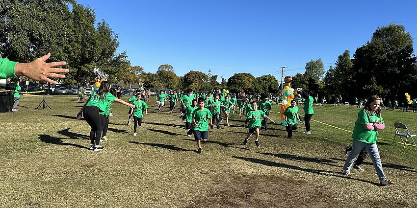 Children running and walking on a grass field
