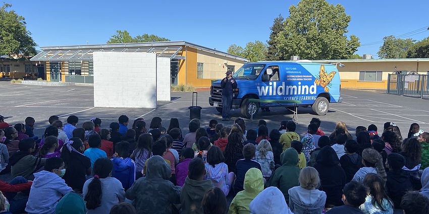 A van in front of student seated outdoors