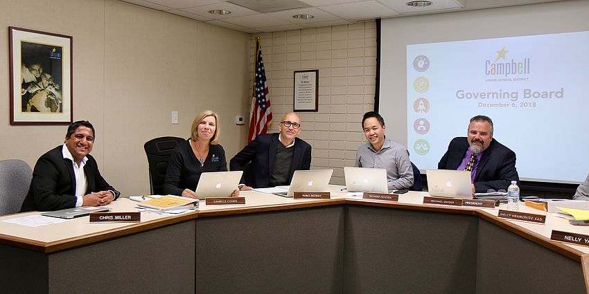 5 governing board members at dais