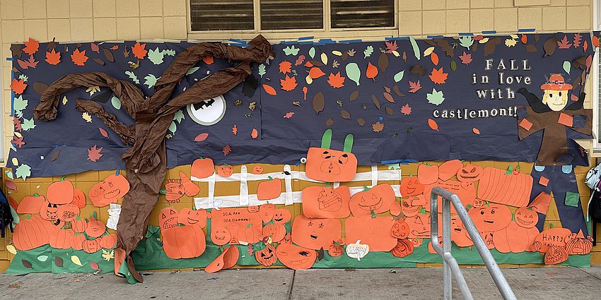 a paper mural of fall pumpkins and a tree