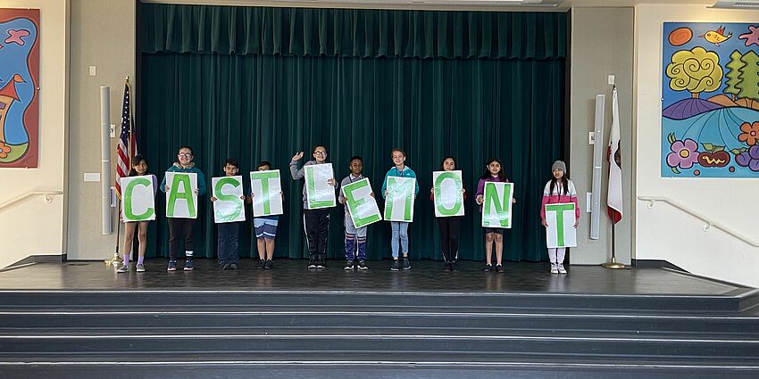 Group of students holding letter signs on a stage