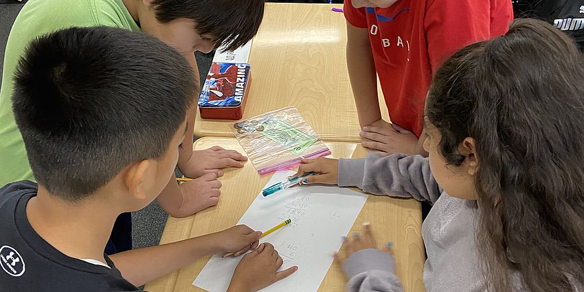 Four students working as a team on a math challenge.