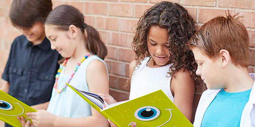 children looking at yearbooks