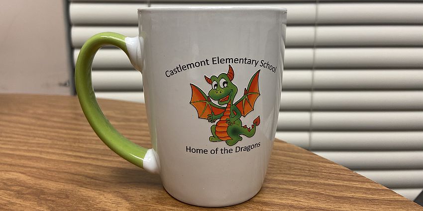 Green and white coffee mug with dragon logo.