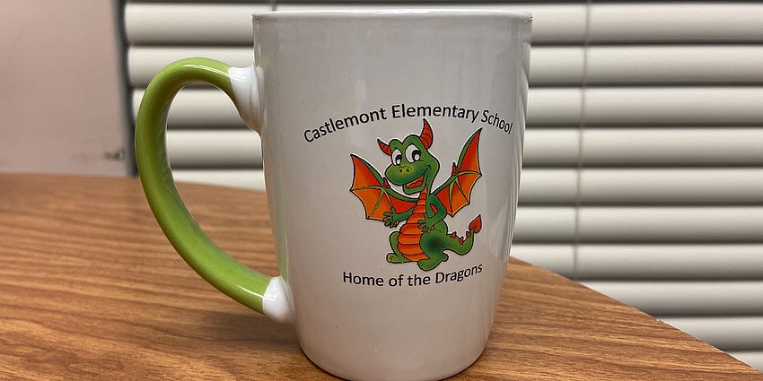 white and green coffee mug with a dragon logo