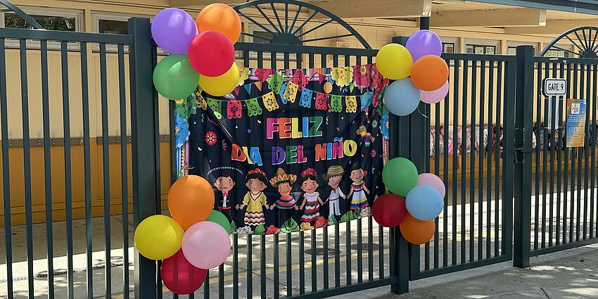 colorful sign and balloons for Dia de los Ninos