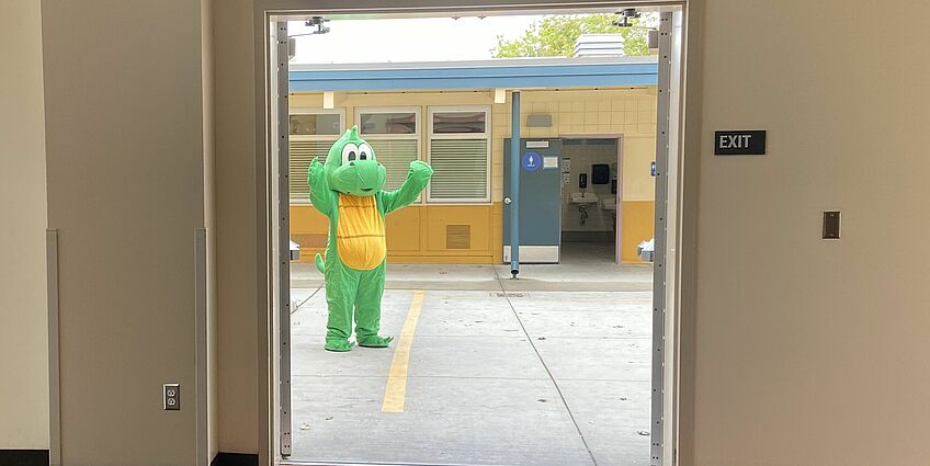 Dragon mascot standing in a doorway