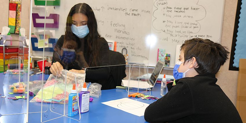 teacher works with young student