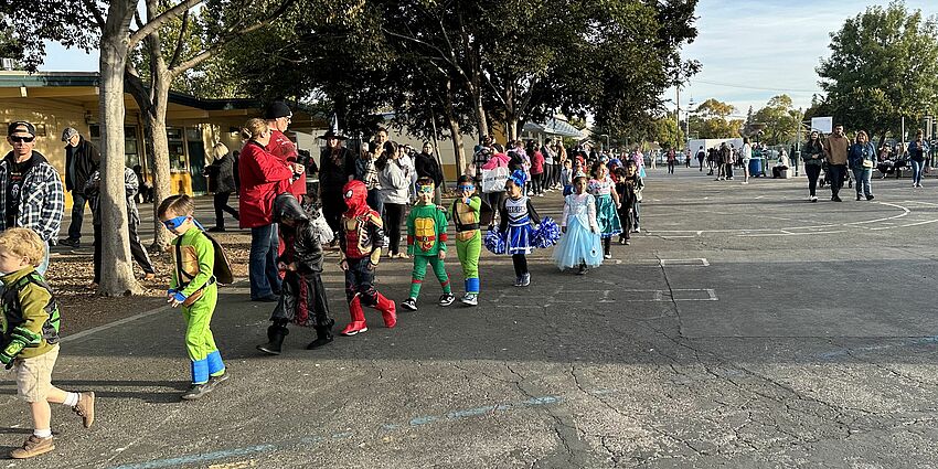 Children in costume walking on a playground