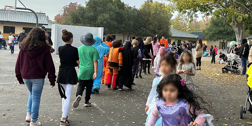 Children in costume walking on a playground