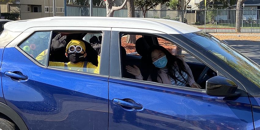 Mother and son in costume in a car at the parade.