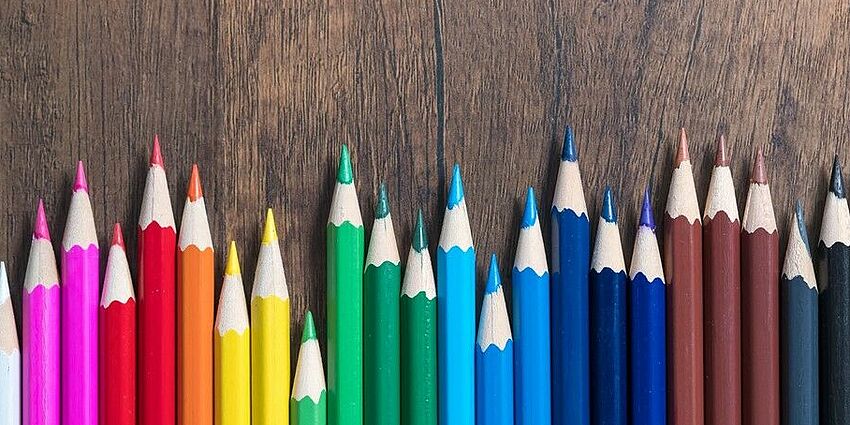 A range of colored pencils in a row.