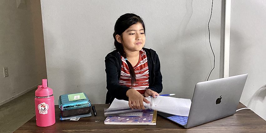 Girl sitting at desk working on her laptop computer.