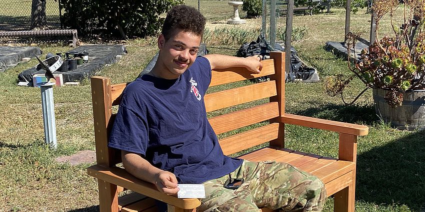 Man sits on a bench in a garden