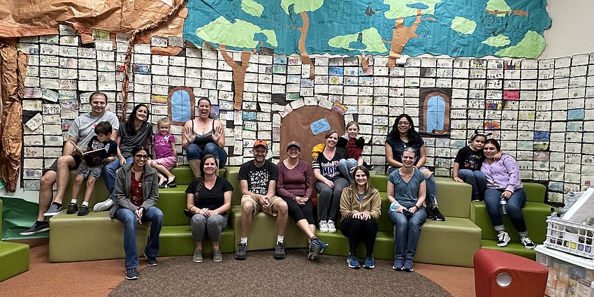 A group of adults and children sitting in a library