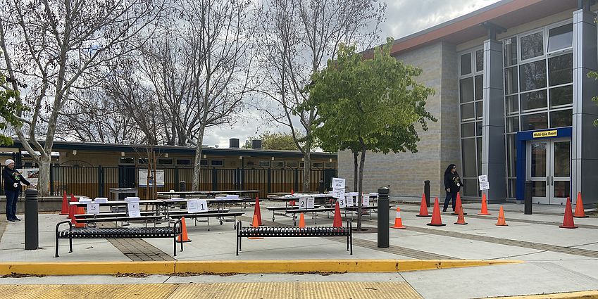 Courtyard set with tables and safety cones. The multi-use room is to the right..