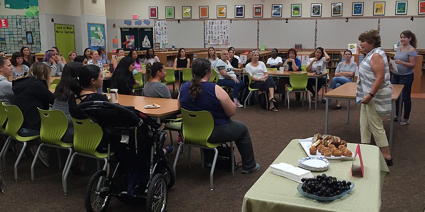 Forty-nine parent volunteers seated in the Castlemont Library.