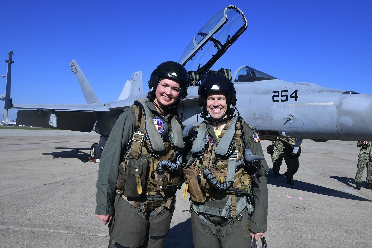 Castlemont teacher, Hailey Robinson, and the Navy pilot she flew with in the F-18 (pictured behind them).