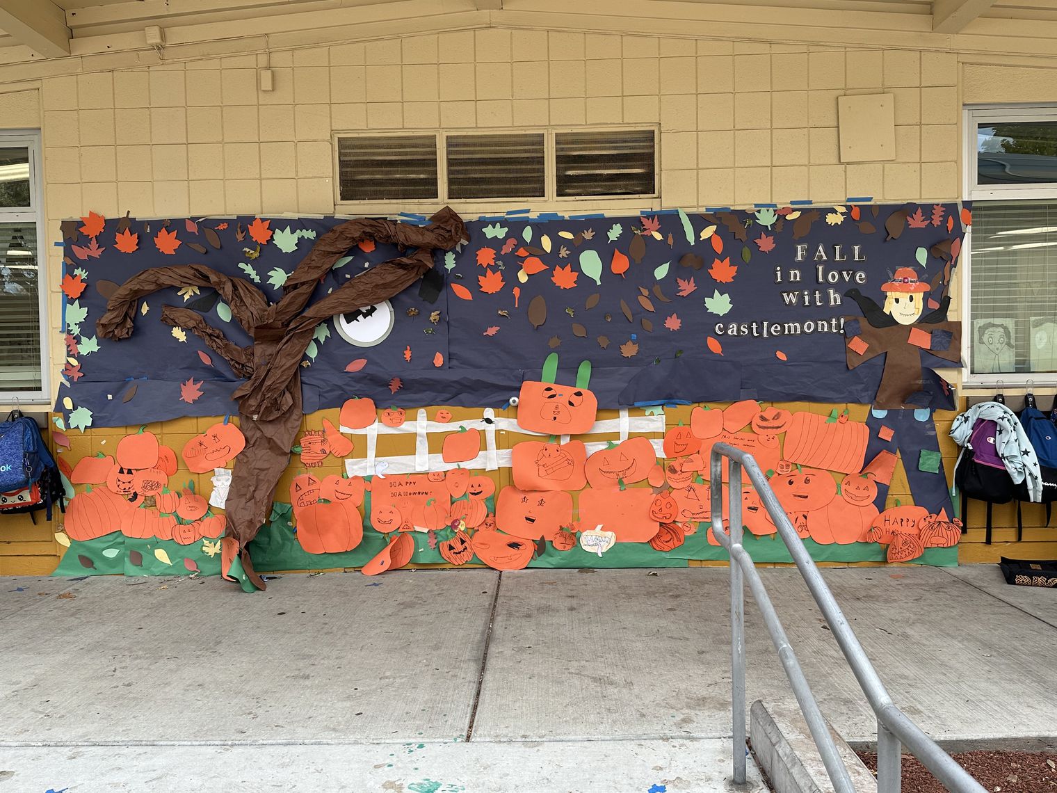 a paper mural of fall pumpkins and a tree