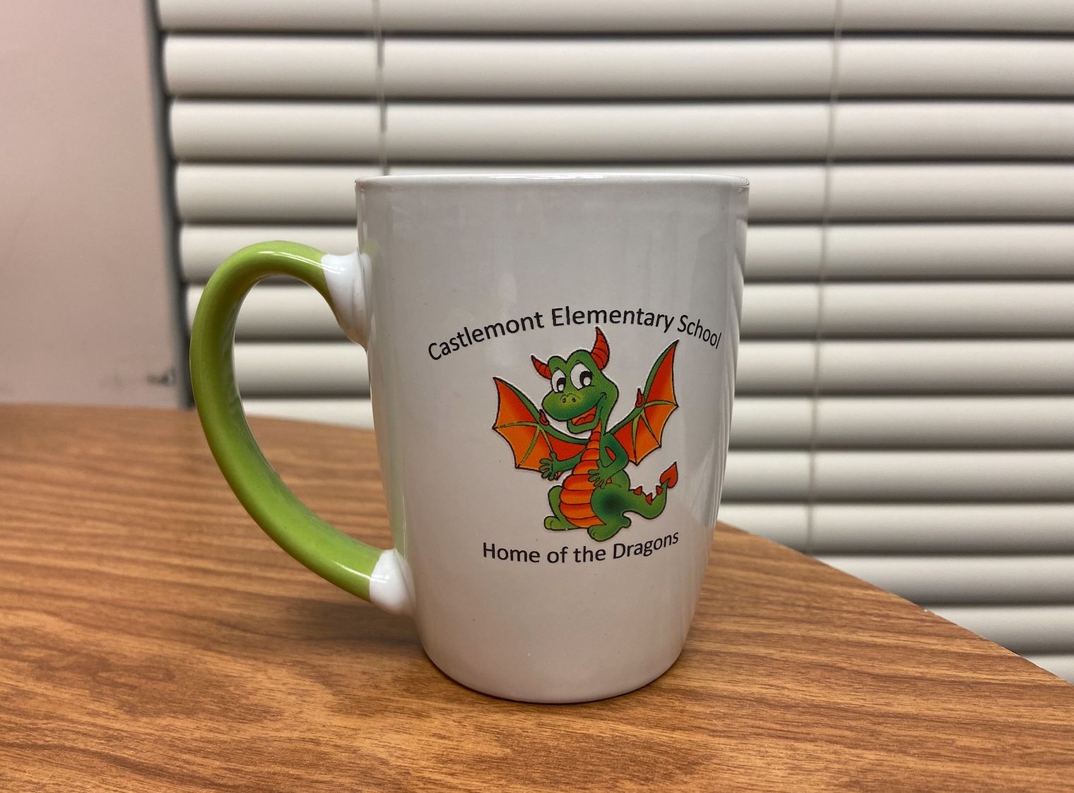 white and green coffee mug with a dragon logo