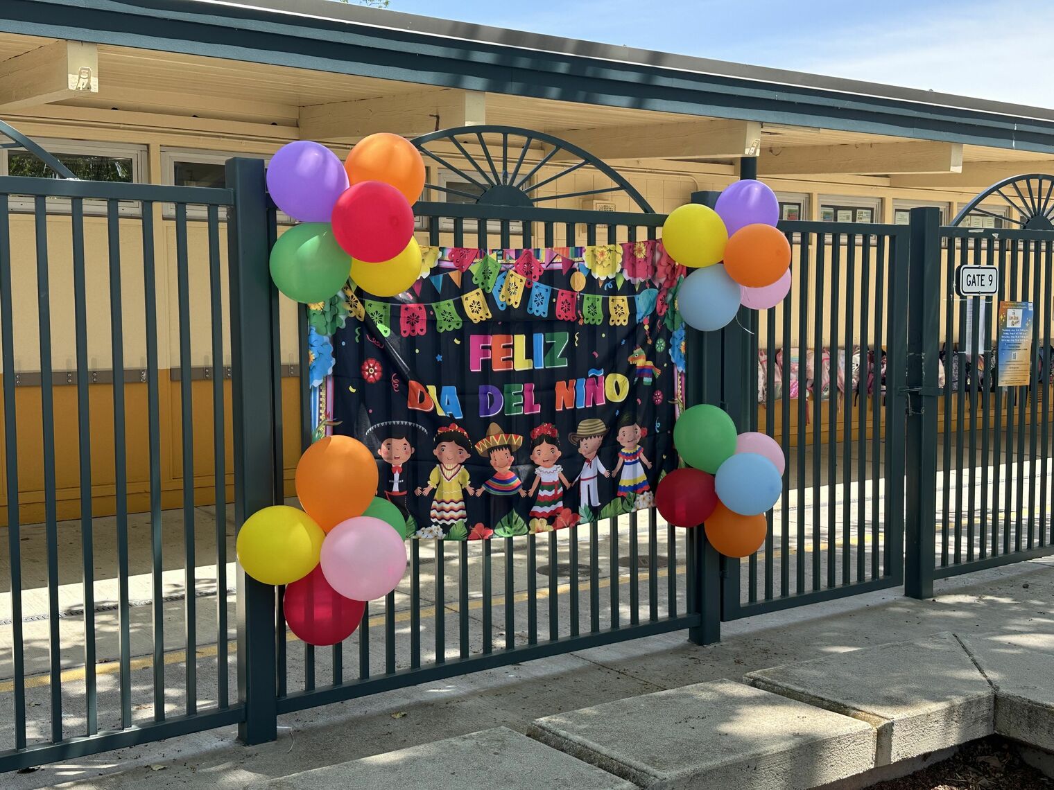 colorful sign and balloons for Dia de los Ninos