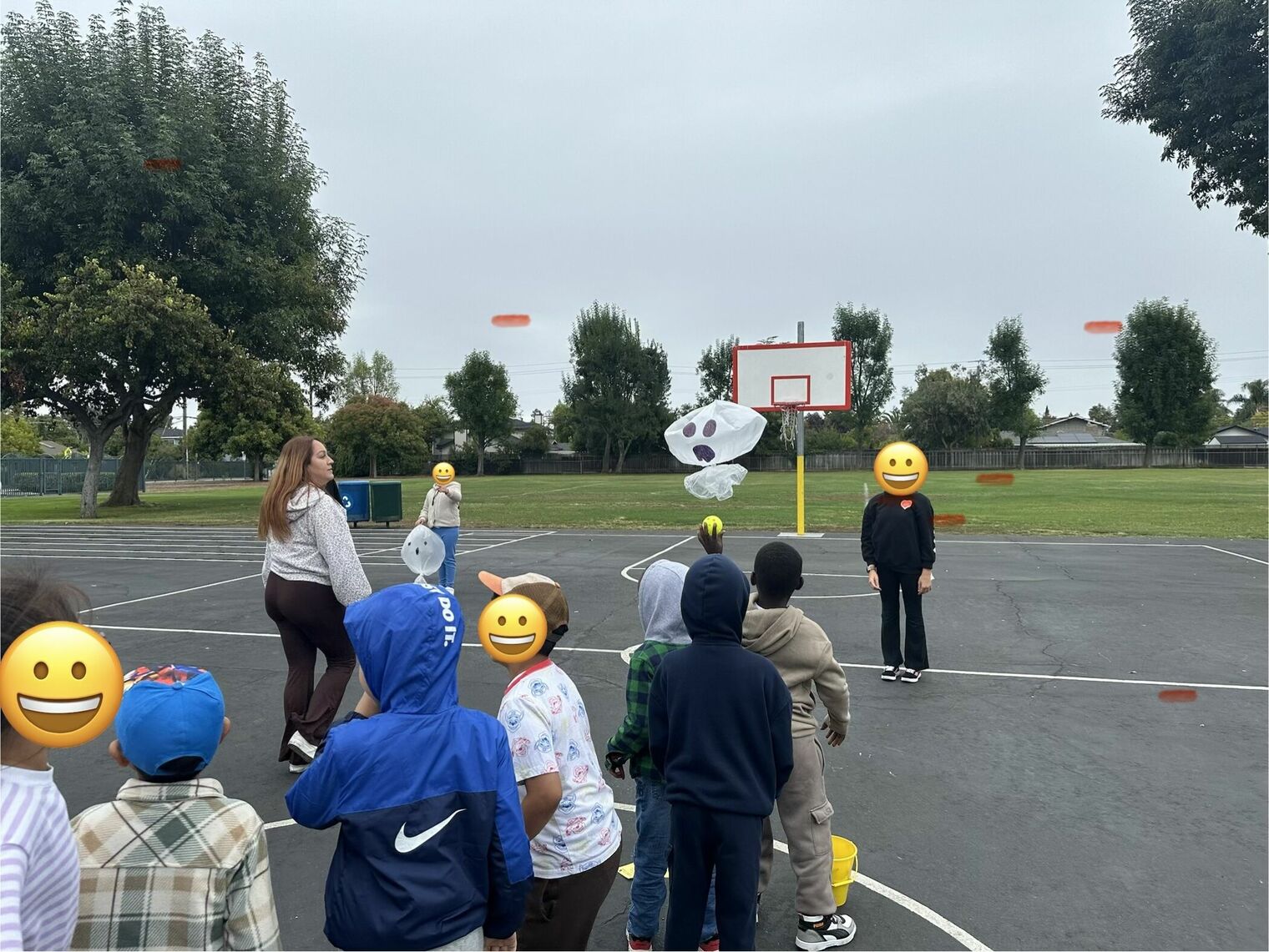 A line of elementary school students enthusiastically play a game on a playground.