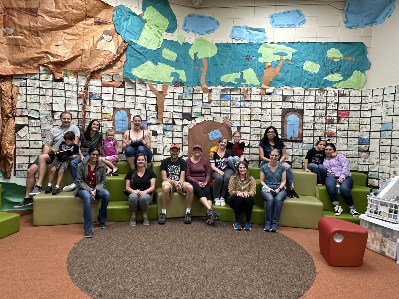 A group of adults and children sitting in a library