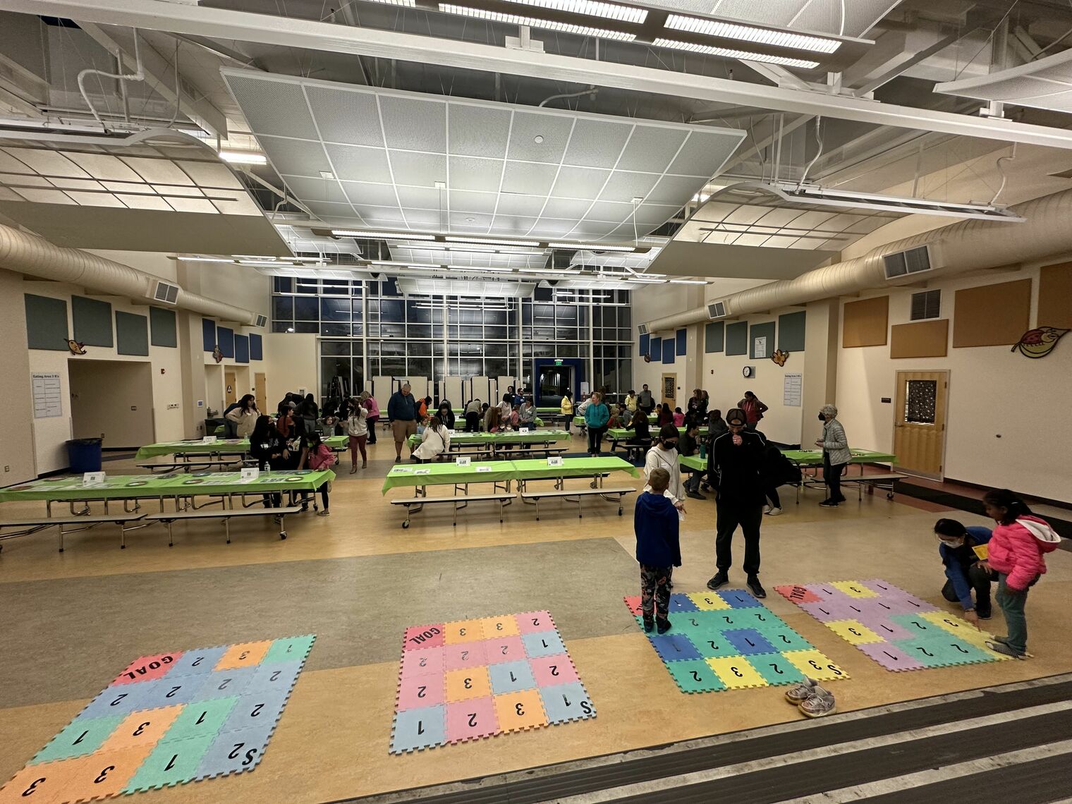 Families playing math games in a large room.